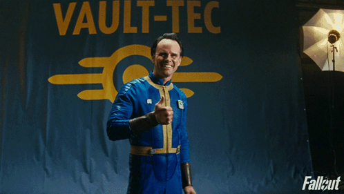 A Man Giving A Thumbs Up In Front Of A Sign That Says Vault GIF