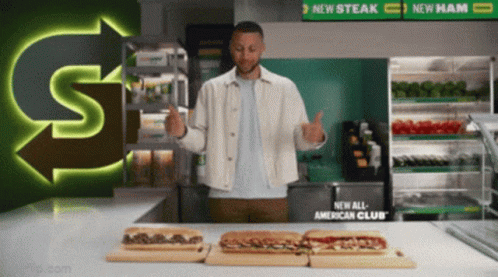 A Man Giving A Thumbs Up In Front Of Subway Sandwiches GIF