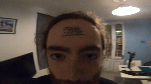 A Man Has A Tattoo On His Forehead That Says ' I Am A Fool ' GIF