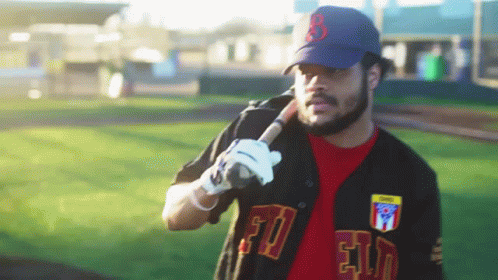 A Man Holding A Baseball Bat With The Letter B On The Hat GIF