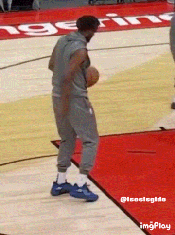 A Man Holding A Basketball On A Basketball Court With The Word Ing On The Floor GIF