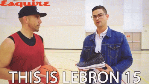 A Man Holding A Basketball Talks To Another Man Who Is Holding A Pair Of Lebron 15 Sneakers GIF