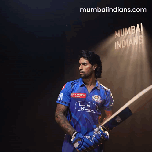 A Man Holding A Bat In Front Of A Sign That Says ' Mumbai Indians ' GIF