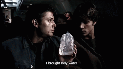 A Man Holding A Bottle That Says I Brought Holy Water On It GIF