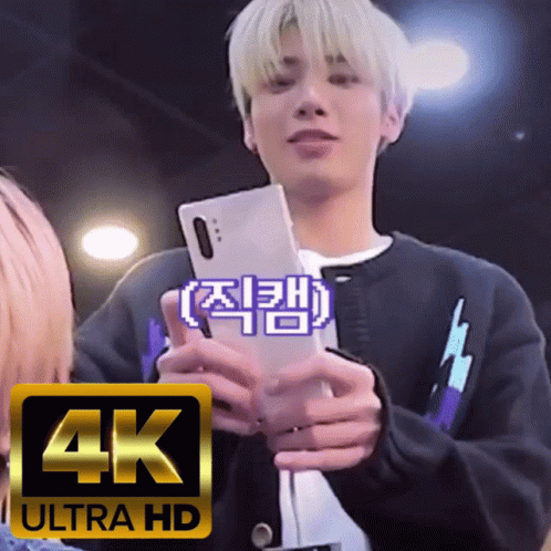 A Man Holding A Cell Phone With A 4K Ultra Hd Logo In The Corner GIF