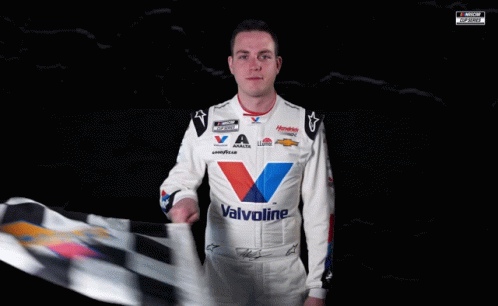 A Man Holding A Checkered Flag That Says Valvol On His Shirt GIF