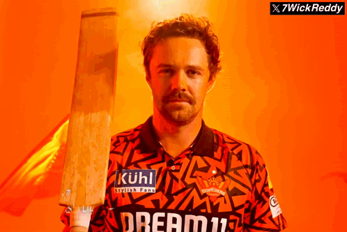 A Man Holding A Cricket Bat With Kuhl Written On His Shirt GIF