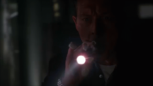 A Man Holding A Flashlight In The Dark GIF