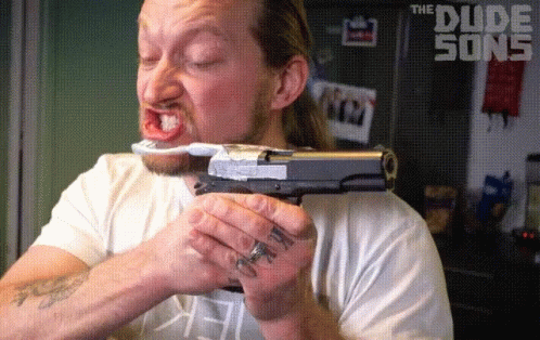 A Man Holding A Gun And A Toothbrush With The Dude Song Written On The Bottom GIF