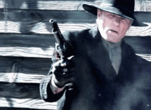 a man holding a gun in front of a wooden wall with the year 2022 on the bottom right
