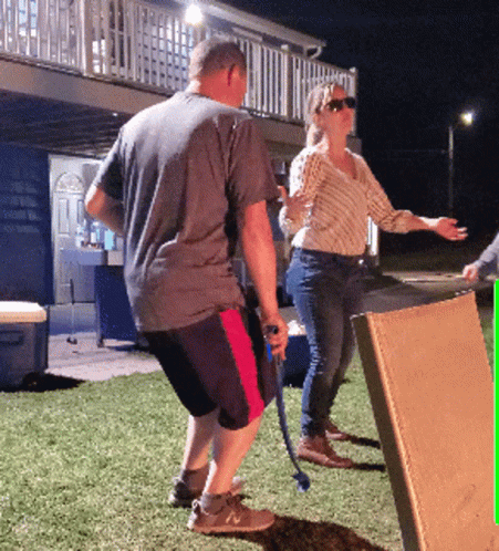 Man Holding Hose Next To Woman And Box GIF