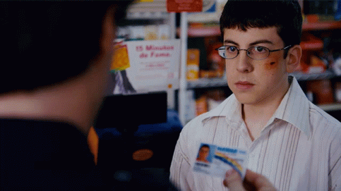 A Man Holding A Id Card In Front Of A Sign That Says 15 Minutes GIF