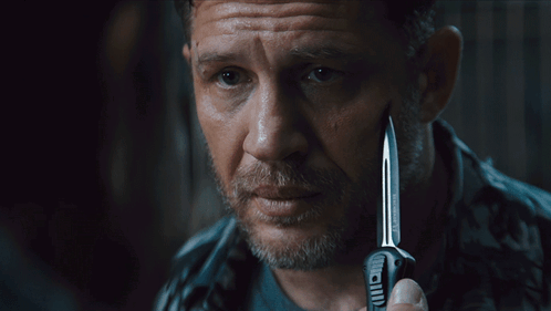 A Man Holding A Knife With The Words Say When Written On The Bottom GIF