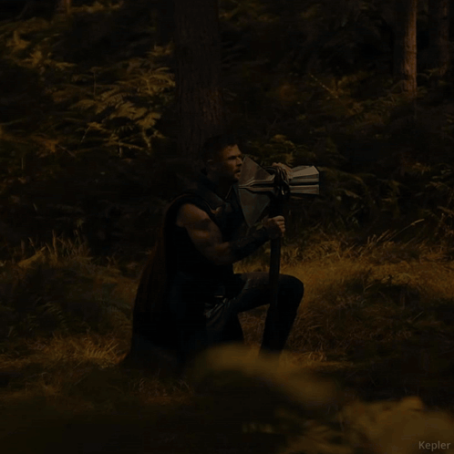 A Man Holding A Large Axe In A Forest With The Name Kepler Visible In The Corner GIF