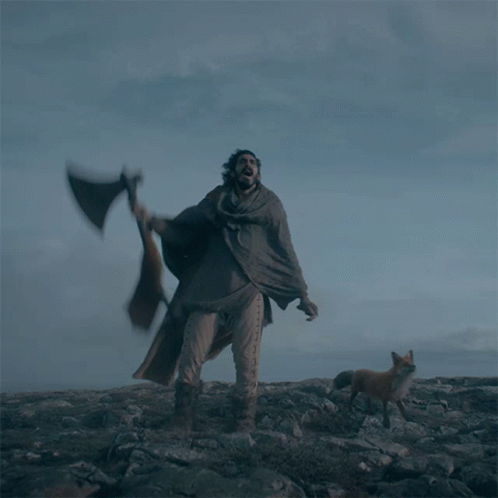 Man With Axe And Fox Nearby On Rocky Hill GIF
