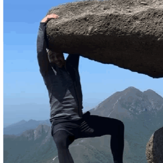 A Man Holding A Large Rock Over His Head GIF