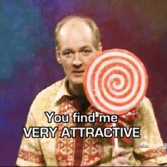 A Man Holding A Lollipop With The Words You Find Me Very Attractive Below Him GIF