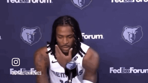 A Man Holding A Microphone In Front Of A Fedex Forum Logo GIF