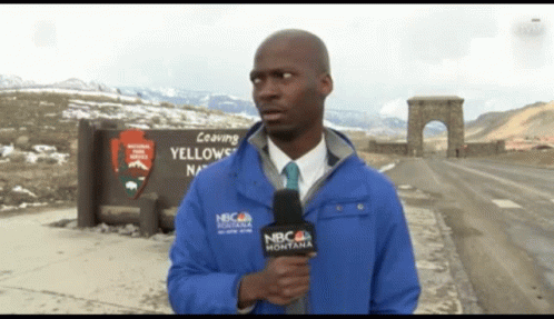 A Man Holding A Microphone In Front Of A Sign That Says " Leaving Yellowstone " GIF