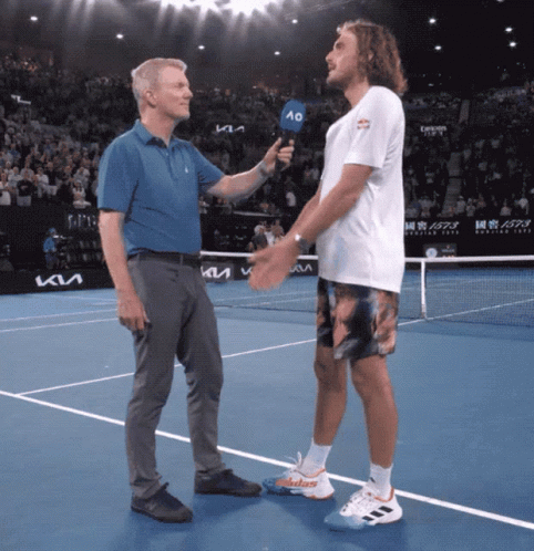 A Man Holding A Microphone Talks To A Tennis Player On The Court GIF