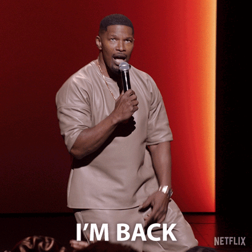 A Man Holding A Microphone With The Word I 'M Back On The Bottom GIF
