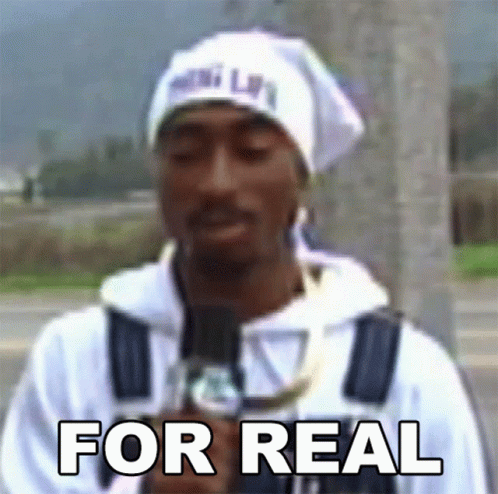 A Man Holding A Microphone With The Words For Real Written On His Chest GIF
