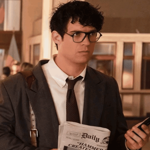 A Man Holding A Newspaper That Says Daily GIF