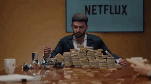 A Man Holding A Pile Of Money In Front Of A Netflix Sign GIF
