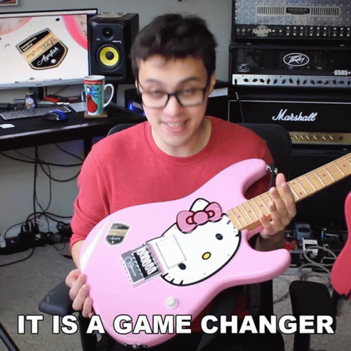 A Man Holding A Pink Hello Kitty Guitar With The Words It Is A Game Changer GIF