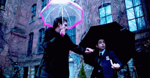 A Man Holding A Pink Umbrella And A Man Holding A Black Umbrella . GIF