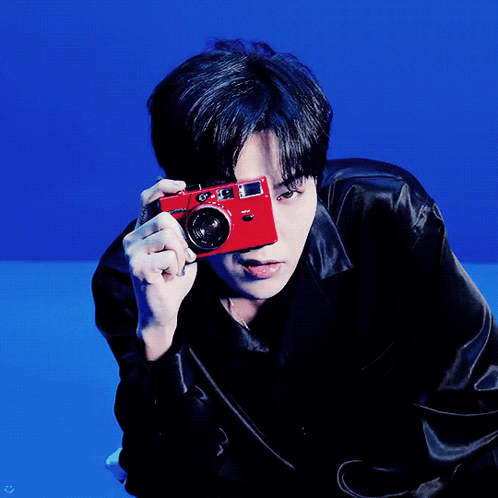 A Man Holding A Red Camera In Front Of His Face GIF