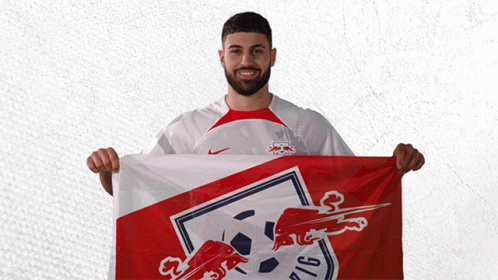 a man holding a red white and blue flag with a bull on it