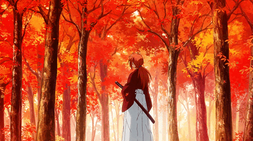 A Man Holding A Sword In A Forest With Red Leaves On The Trees GIF