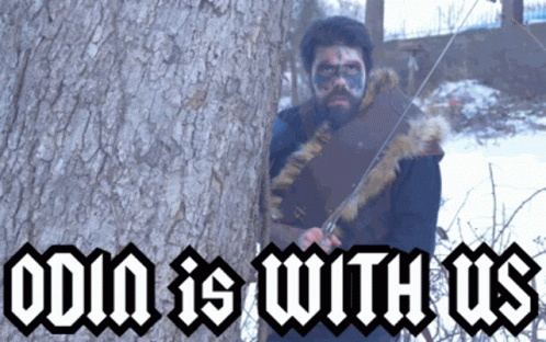 A Man Holding A Sword In Front Of A Tree With The Words Odin Is With Us On The Bottom GIF