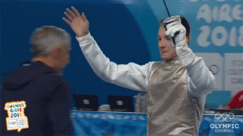 A Man Holding A Sword In Front Of An Olympic Channel Sign GIF