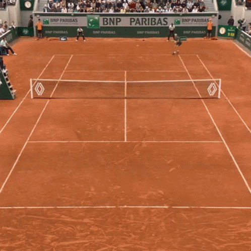 A Man Holding A Tennis Racquet In Front Of A Bnp Banner GIF
