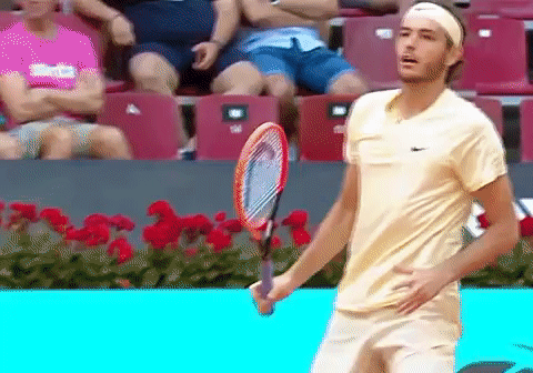 A Man Holding A Tennis Racquet In Front Of A Crowd GIF