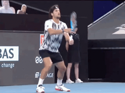 A Man Holding A Tennis Racquet On A Court With A Bas Sign In The Background GIF