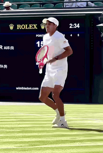 A Man Holding A Tennis Racquet On A Court With A Rolex Sign In The Background GIF