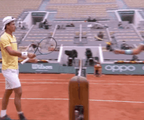 A Man Holding A Tennis Racquet On A Court With An Oppo Sign In The Background GIF