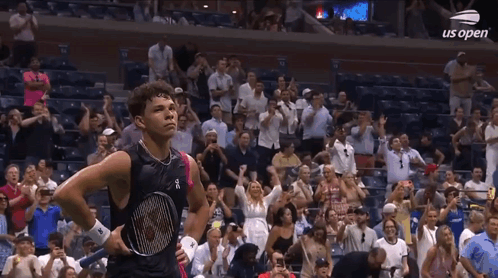 A Man Holding A Tennis Racquet Stands In Front Of A Crowd At Us Open GIF