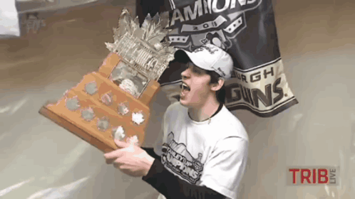 a man holding a trophy in front of a banner that says ' champs ' on it
