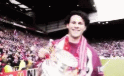 A Man Holding A Trophy In Front Of A Mcdonald 'S Banner GIF