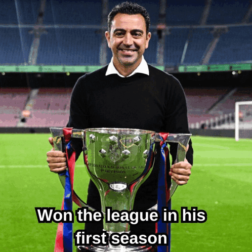 A Man Holding A Trophy That Says ' Won The League In His First Season ' GIF