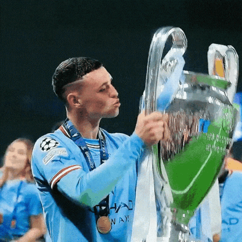 A Man Holding A Trophy With A Medal Around His Neck That Says ' Nay ' On It GIF
