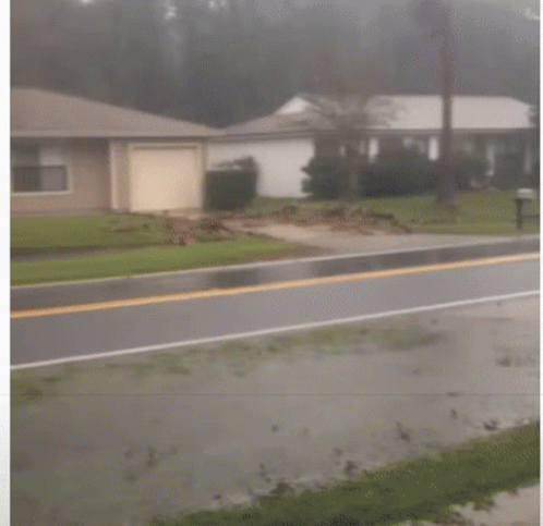 A Man Holding An American Flag Runs Down The Street GIF