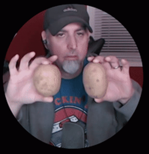 A Man Holding Two Potatoes In Front Of His Face GIF