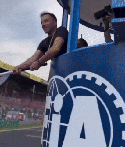 A Man Holds A Flag In Front Of A Large Ia Logo GIF