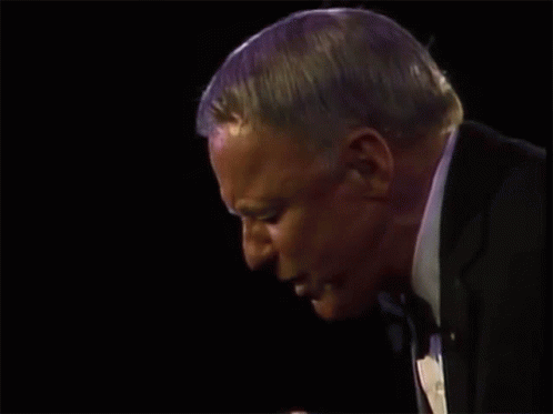 A Man Holds A Microphone And Says Anywhere GIF