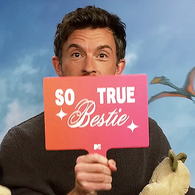 a man holds a sign that says so true bestie